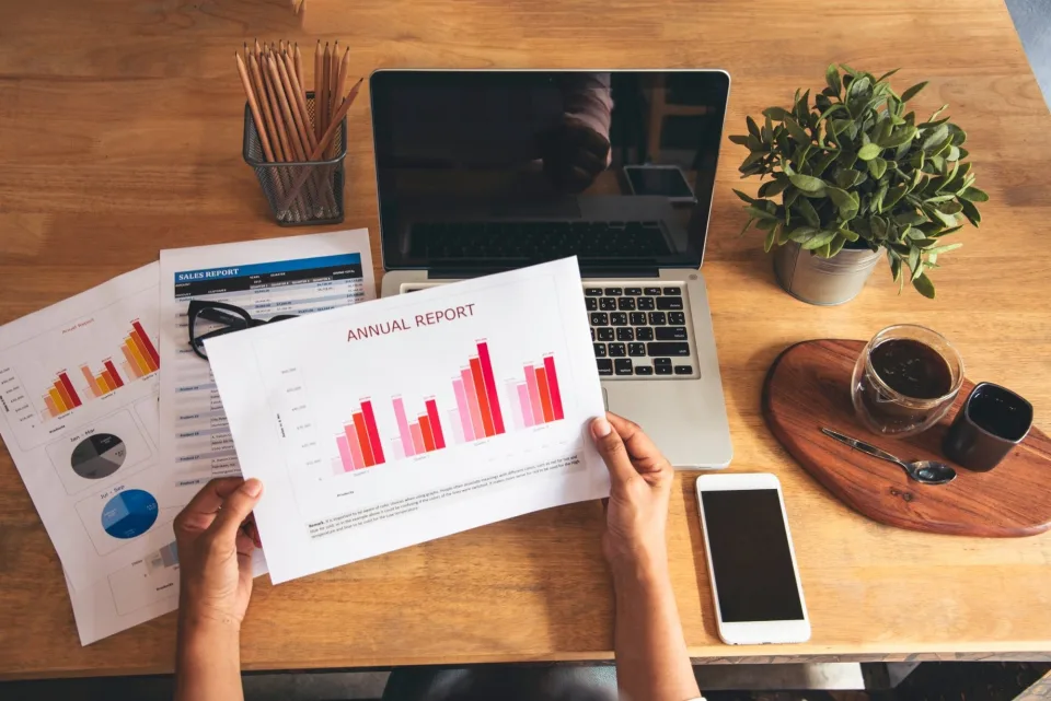 Reviewing market reports and charts at a desk