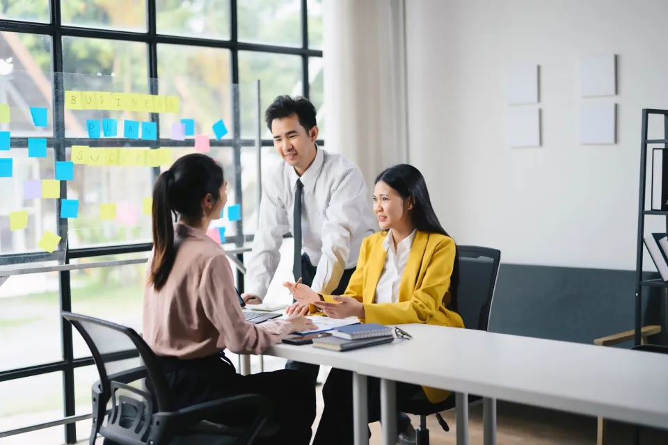 Asian business team discussing plans in a bright office